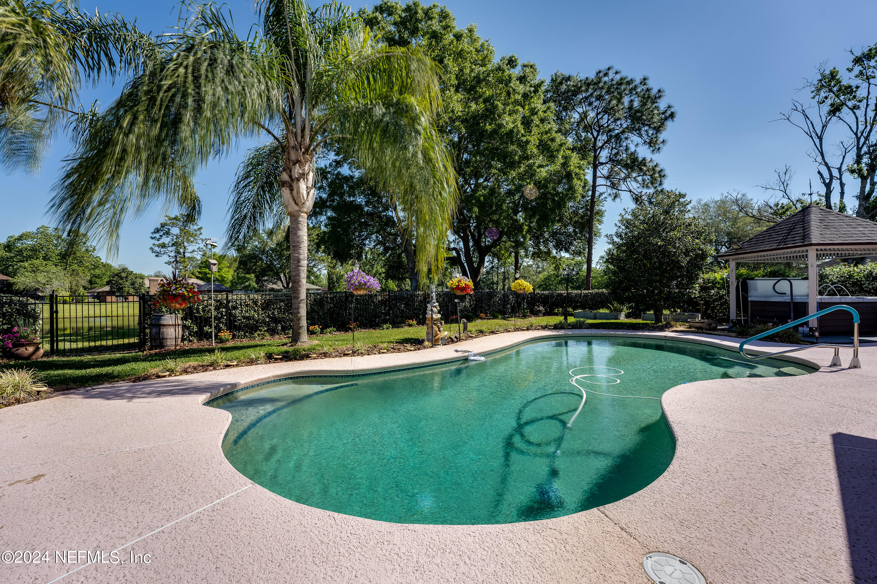 a view of a swimming pool with a yard and palm trees