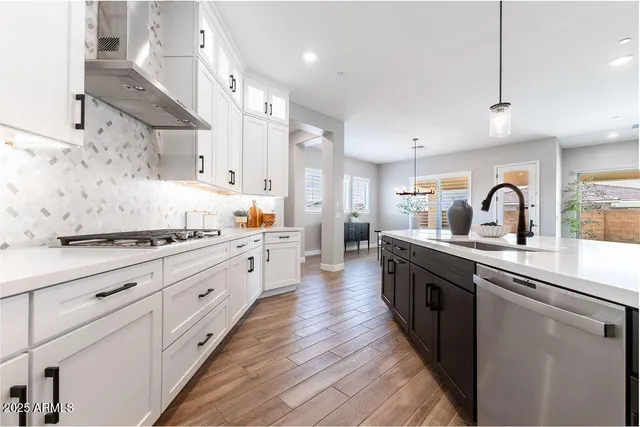 a large kitchen with stainless steel appliances lots of counter space and a sink