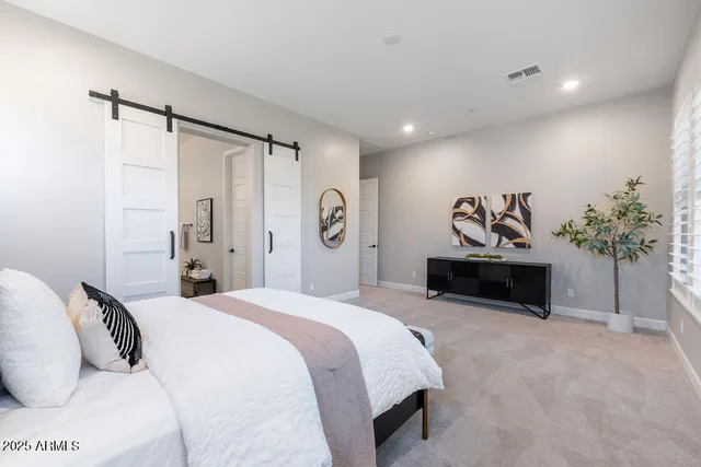 a spacious bedroom with a bed and a potted plant