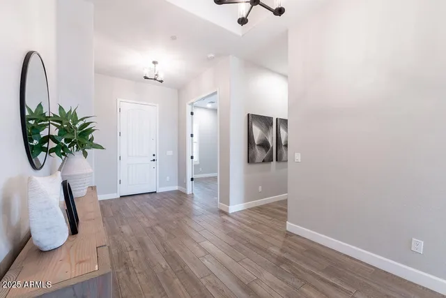 a view of a hallway with wooden floor and a potted plant