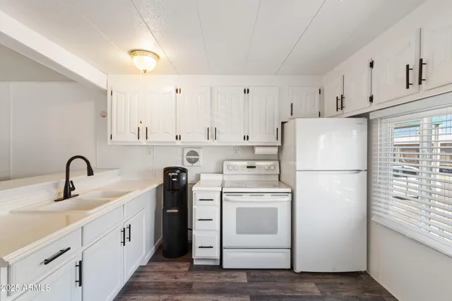 a kitchen with white cabinets and white appliances