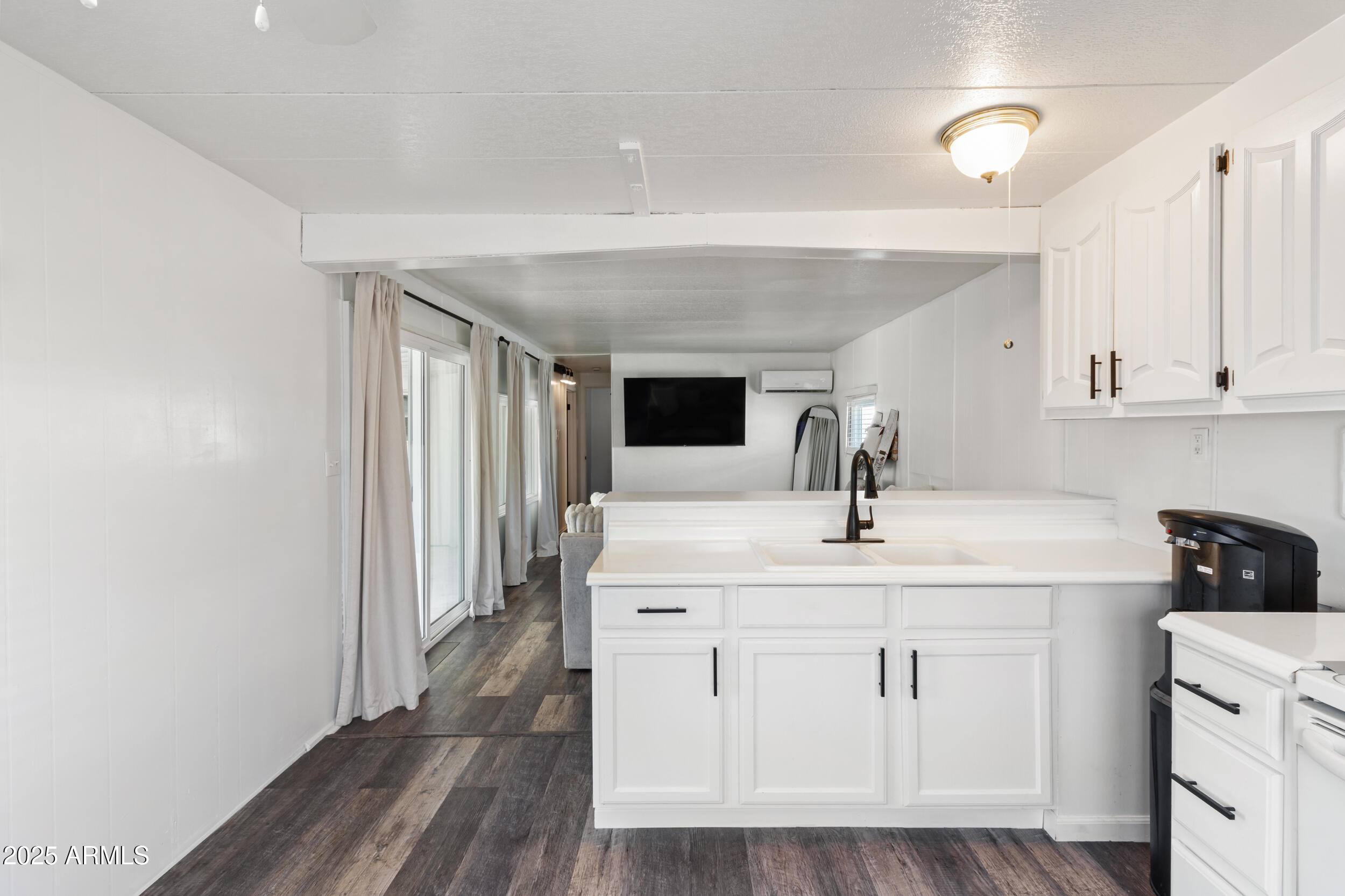 701 South Dobson Road, Unit 357 Mesa, AZ 85202 - Photo 10 of 66 a kitchen with white cabinets a sink and wooden floor