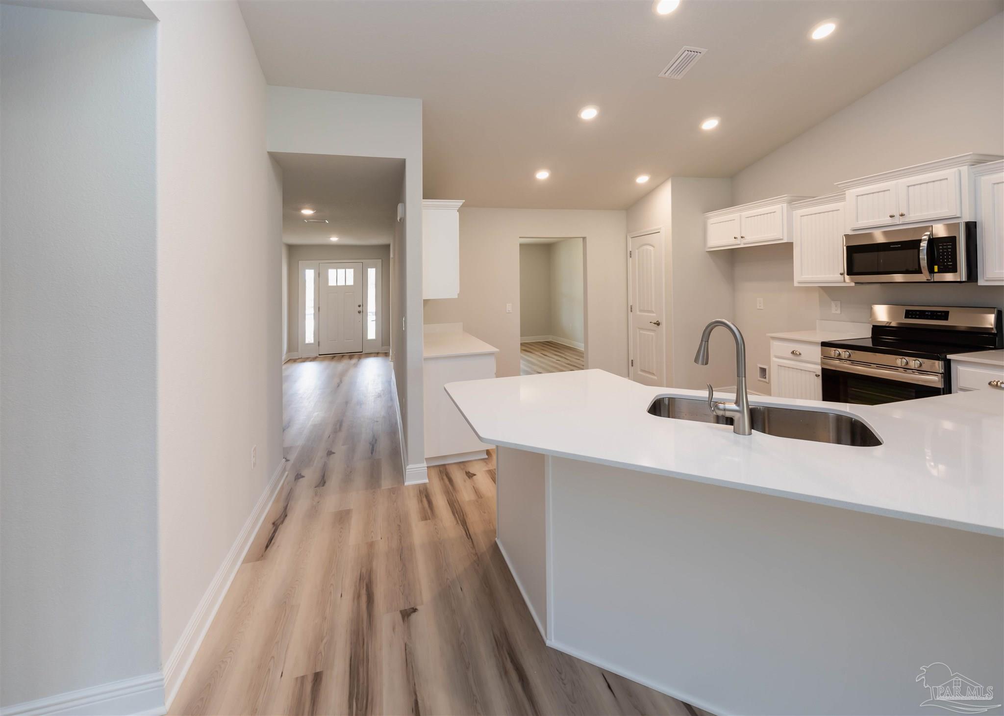6288 Pineapple Drive Milton, FL 32570 - Photo 16 of 32 a kitchen with kitchen island a sink appliances and cabinets