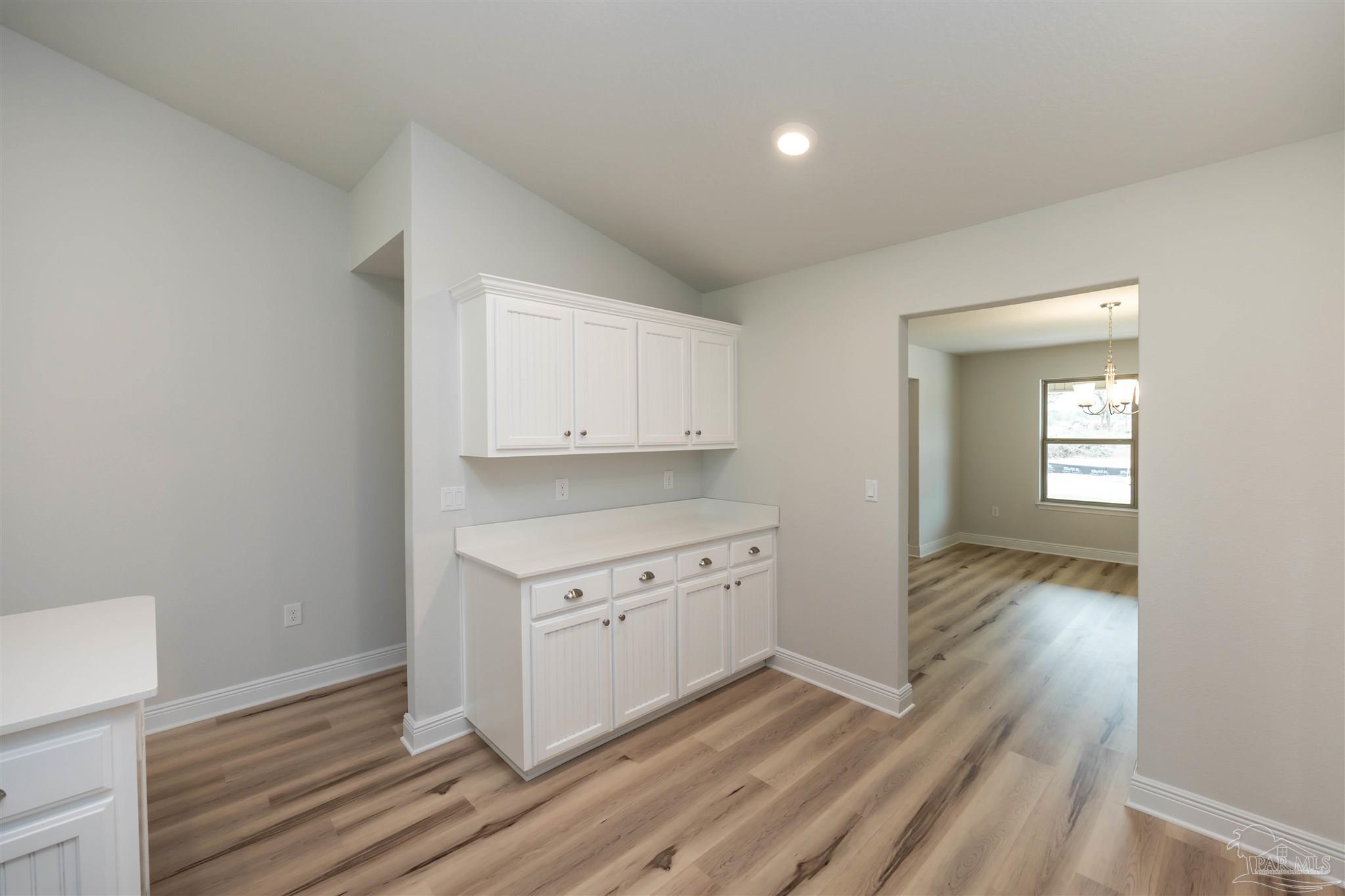 6288 Pineapple Drive Milton, FL 32570 - Photo 17 of 32 a view of a kitchen with wooden floor and cabinets