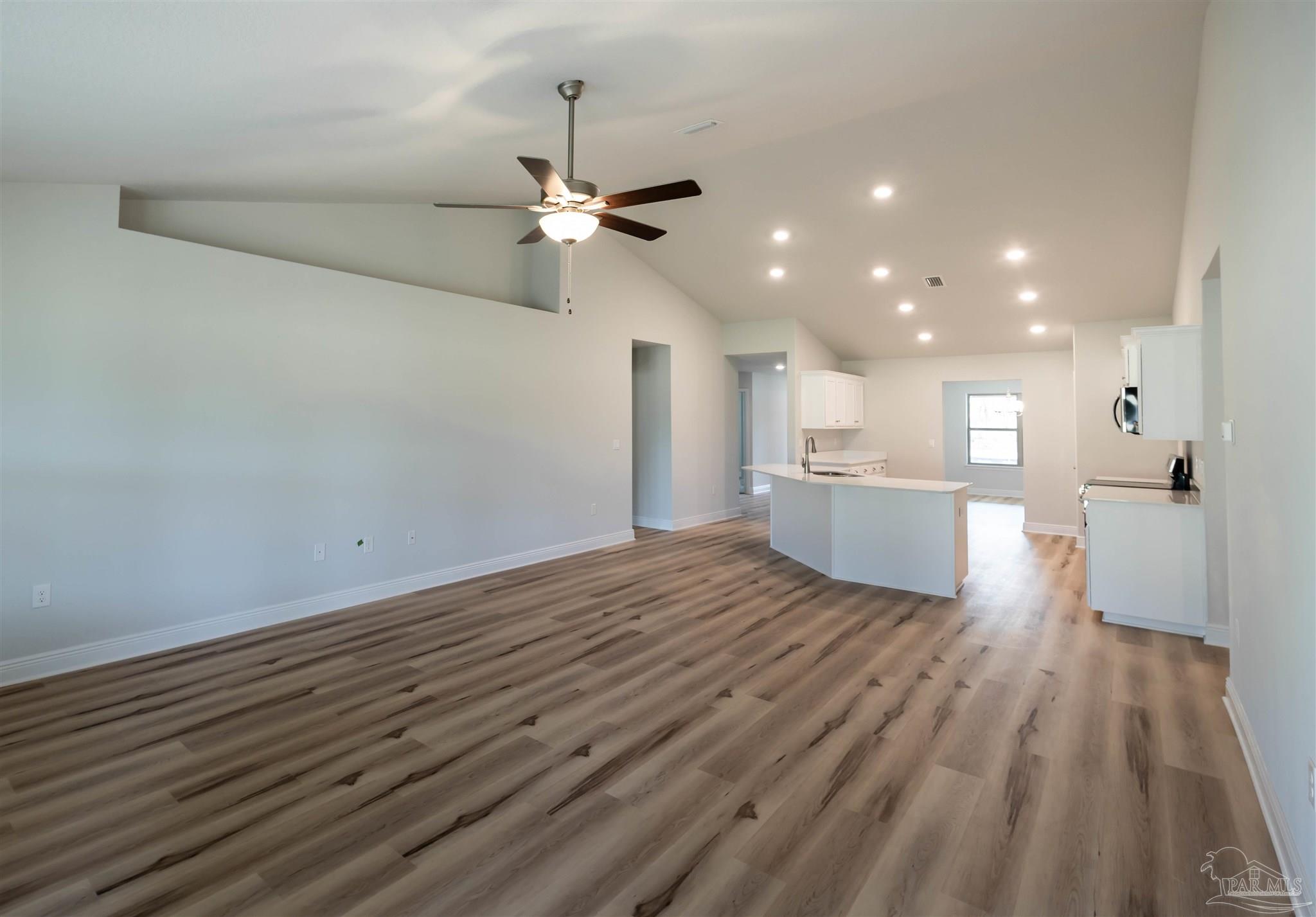6288 Pineapple Drive Milton, FL 32570 - Photo 22 of 32 a view of a kitchen with wooden floor and a ceiling fan