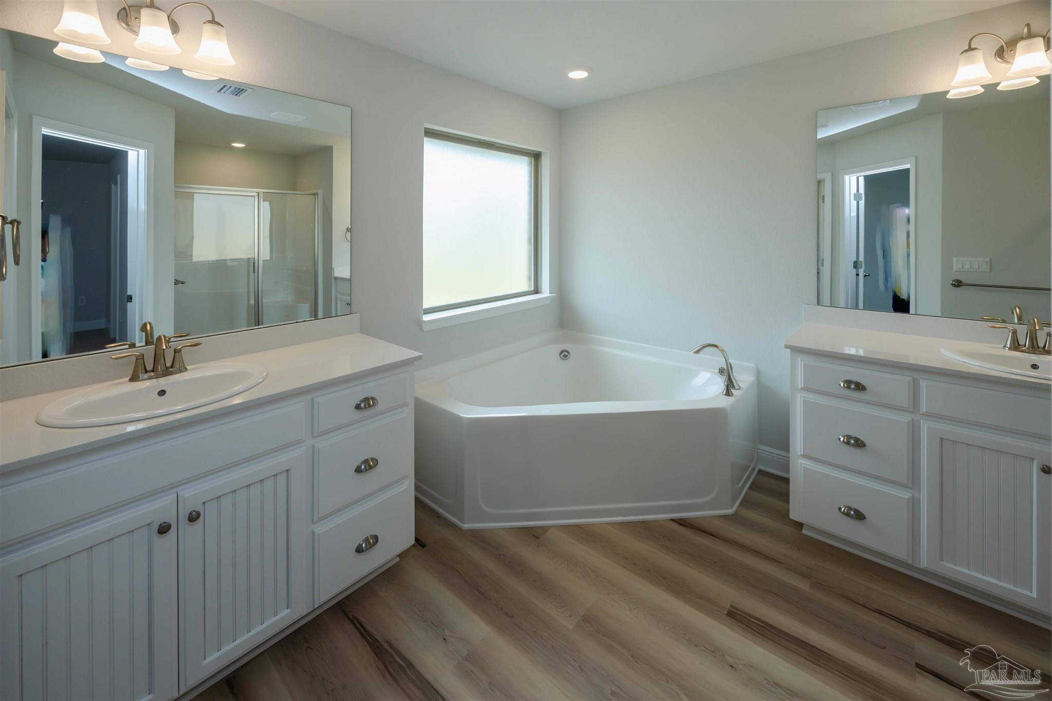 6288 Pineapple Drive Milton, FL 32570 - Photo 29 of 32 a bathroom with a double vanity sink a mirror and a bathtub