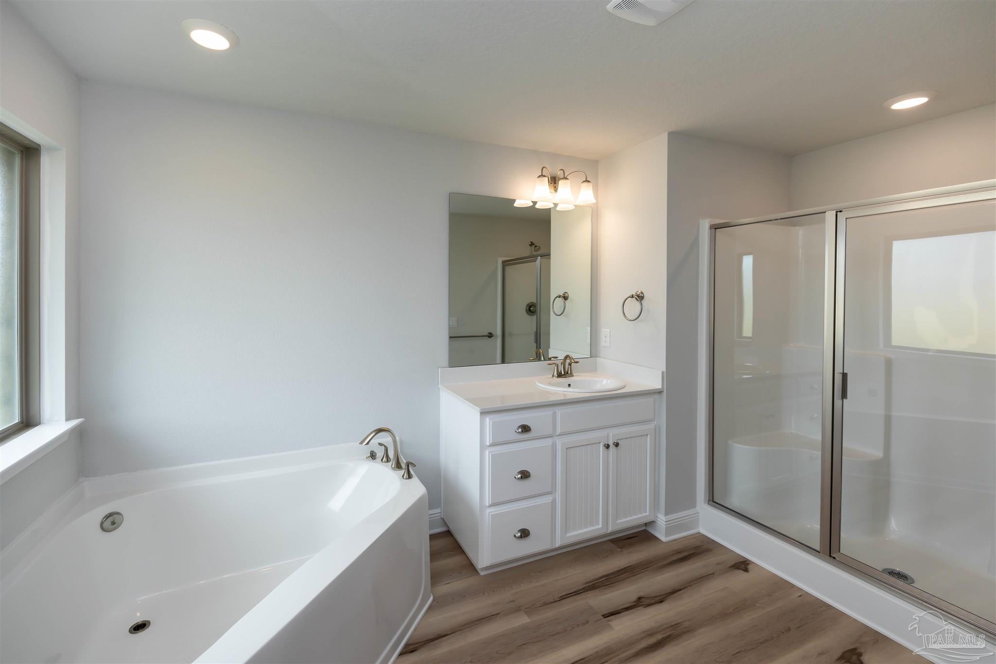 6288 Pineapple Drive Milton, FL 32570 - Photo 30 of 32 a bathroom with a tub a double vanity sink and mirror