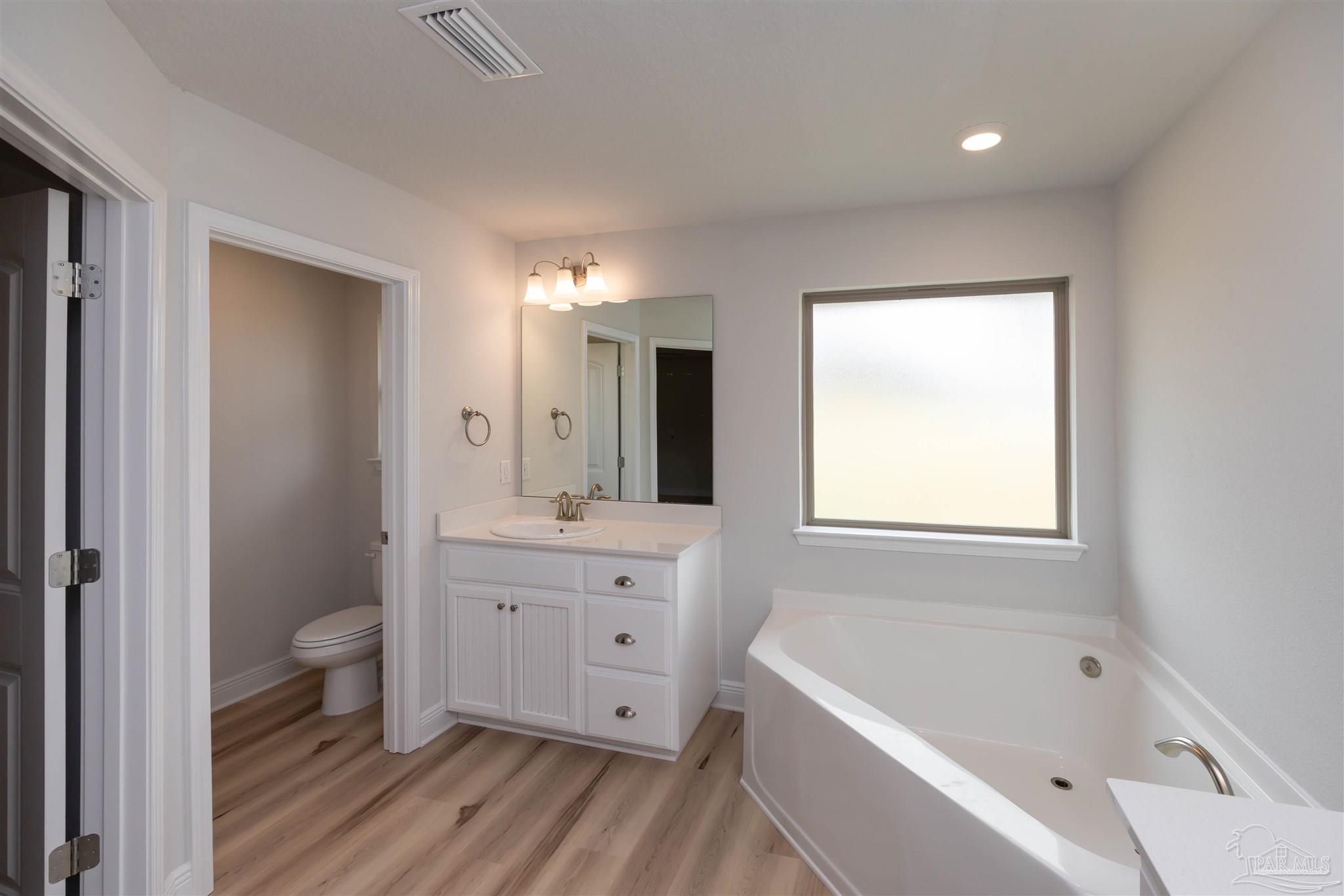 6288 Pineapple Drive Milton, FL 32570 - Photo 31 of 32 a bathroom with a double vanity sink a toilet a bathtub and shower