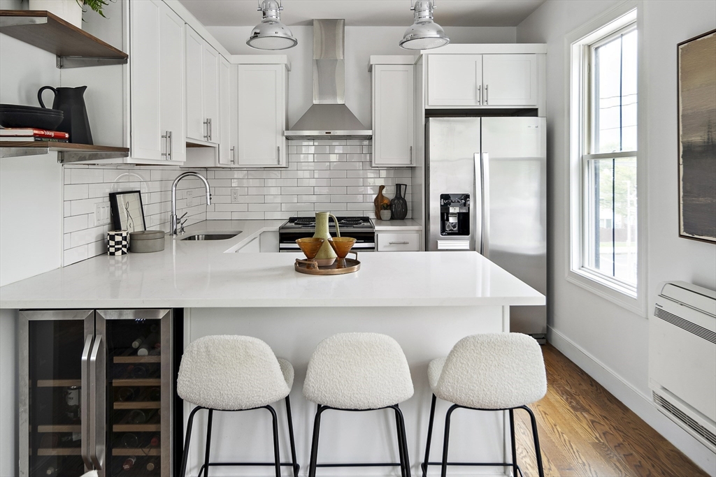 9 Cedar Street, Unit 1 Boston, MA 02119 - Photo 1 of 29 a kitchen with stainless steel appliances a dining table chairs refrigerator and sink