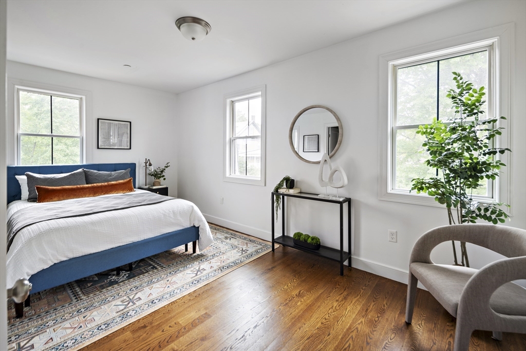9 Cedar Street, Unit 1 Boston, MA 02119 - Photo 13 of 29 a bedroom with a bed a dresser with wooden floor