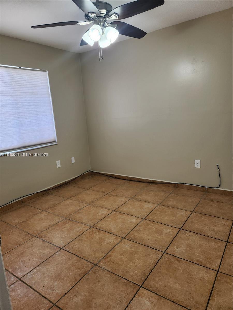 18303 Southwest 139th Place Miami, FL 33177 - Photo 11 of 19 an empty room with a ceiling fan and carpet