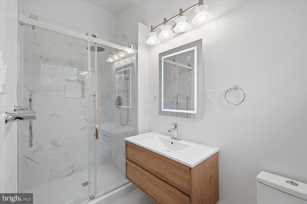 822 Walker Road Great Falls, VA 22066 - Photo 16 of 32 a bathroom with a shower a mirror and a sink