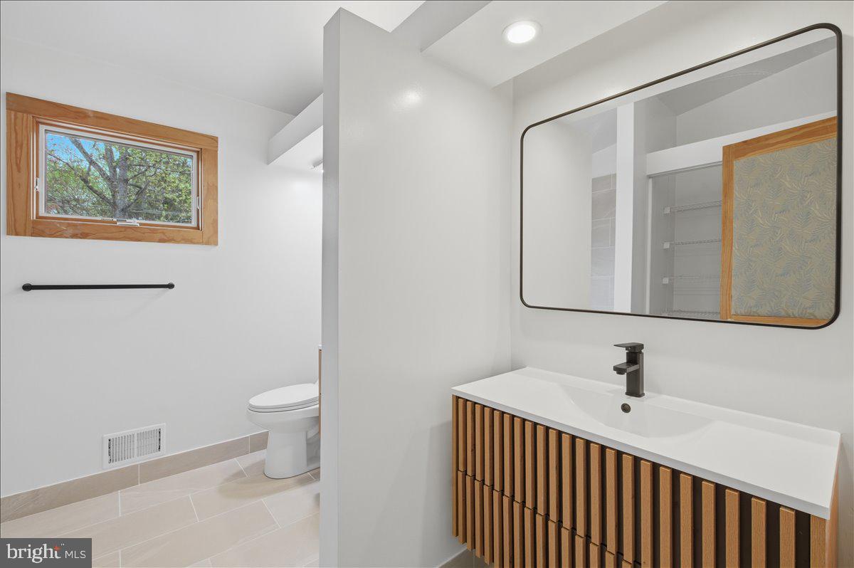 822 Walker Road Great Falls, VA 22066 - Photo 17 of 32 a bathroom with a sink a toilet and mirror