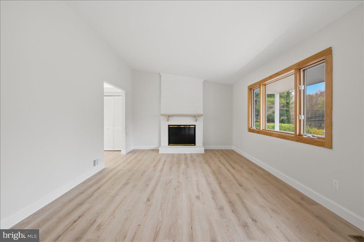 822 Walker Road Great Falls, VA 22066 - Photo 3 of 32 a view of an empty room with a fireplace and a window