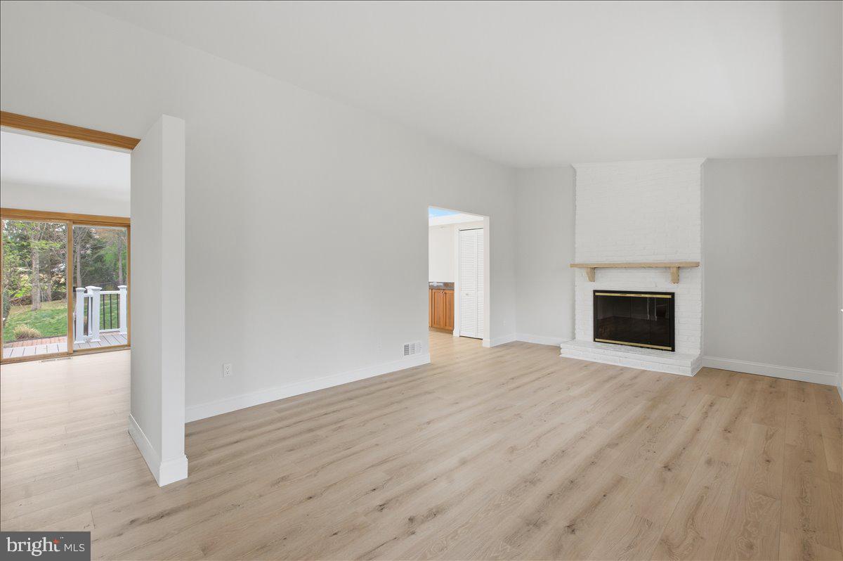 822 Walker Road Great Falls, VA 22066 - Photo 4 of 32 a view of empty room with wooden floor and fireplace