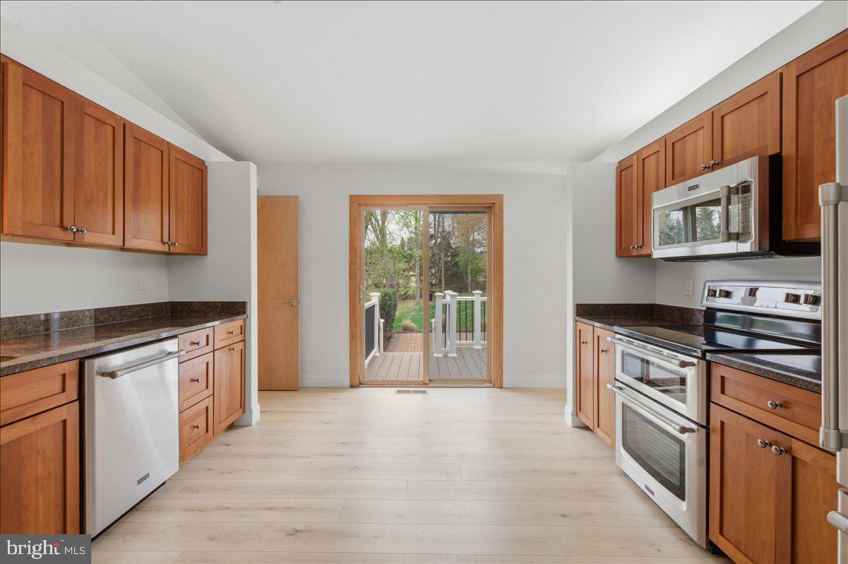 822 Walker Road Great Falls, VA 22066 - Photo 6 of 32 a kitchen with stainless steel appliances granite countertop a stove a sink and a microwave