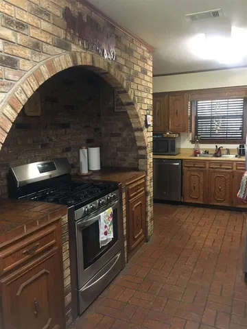 a kitchen with stainless steel appliances granite countertop a stove and a sink