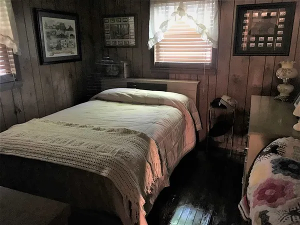 a bedroom with a bed and a painting on the wall