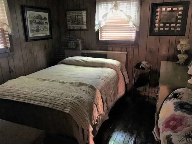 a bedroom with a bed and a painting on the wall