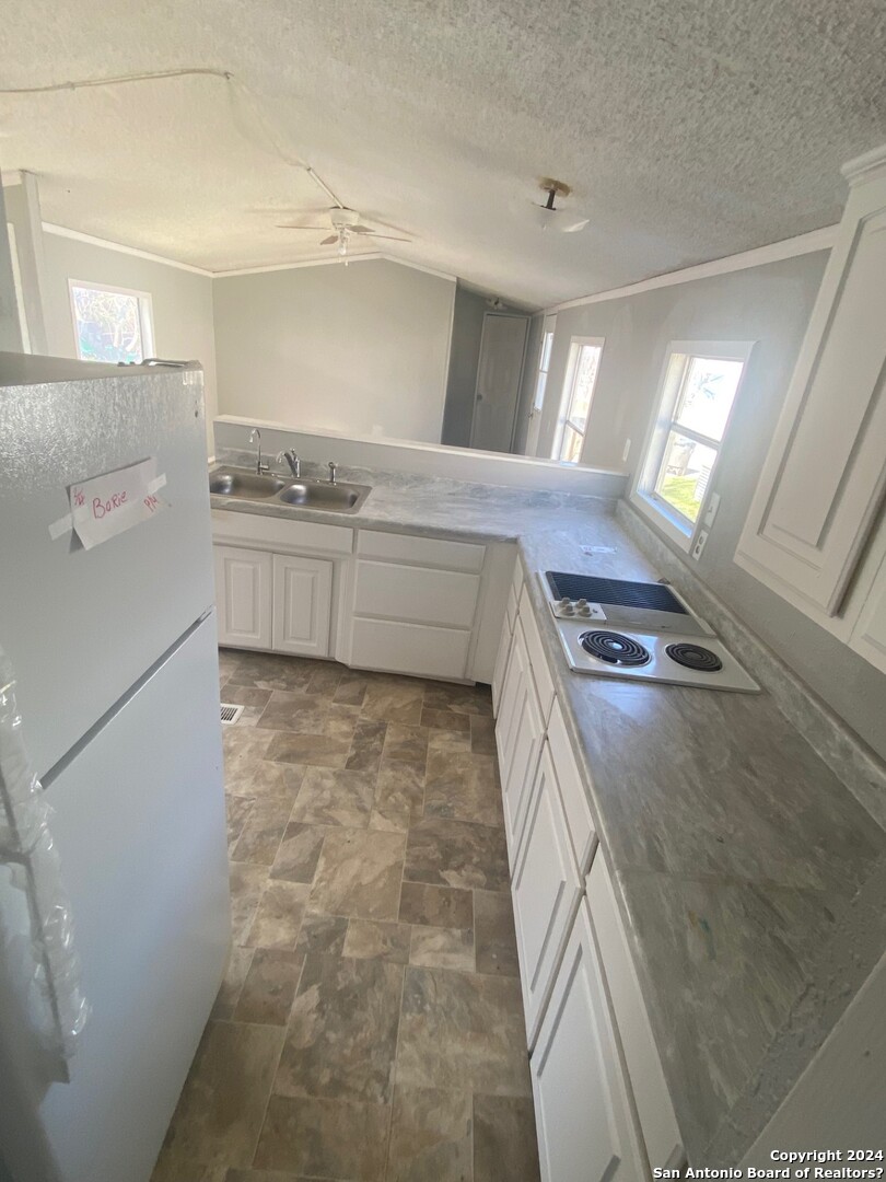 1311 Hein Road West, Unit 19 San Antonio, TX 78220 - Photo 5 of 8 a kitchen with granite countertop a stove and a refrigerator