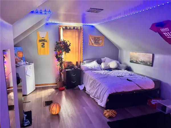 a bedroom with bed and wooden floor