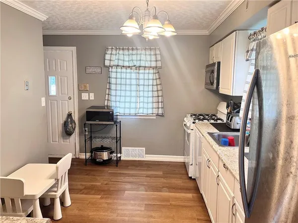 a kitchen that has a lot of furniture and appliances