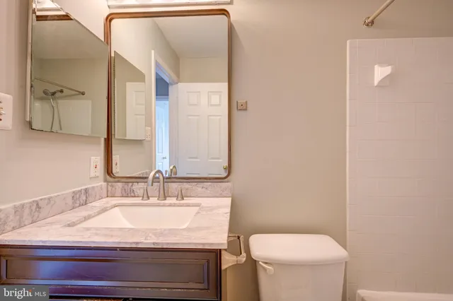 a bathroom with a granite countertop sink and a mirror