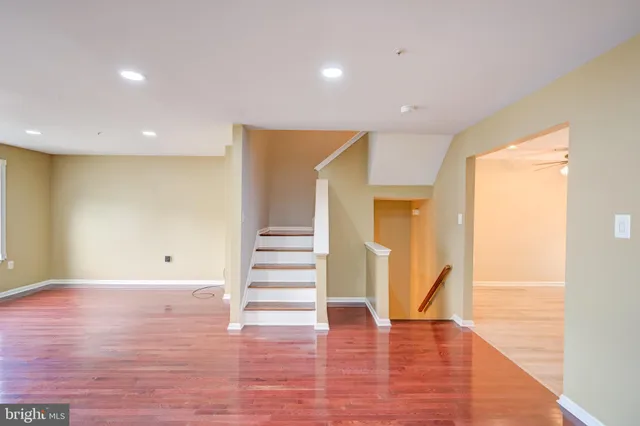a view of an empty room with wooden floor and entryway