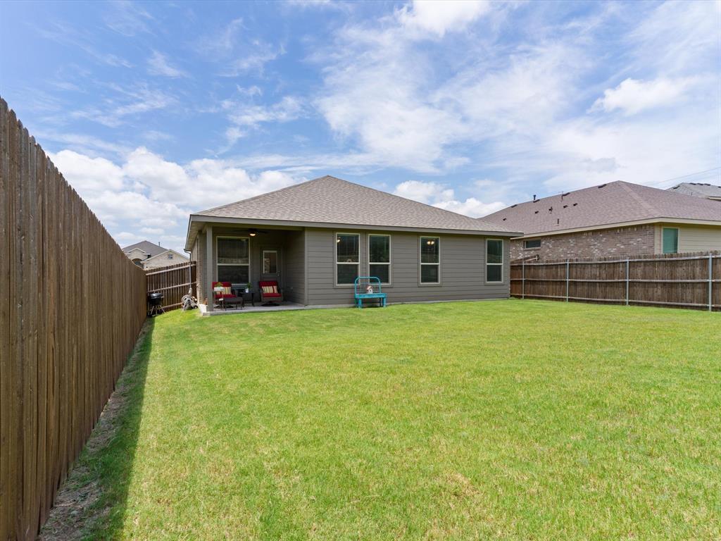 270 Lunayena Road Rhome, TX 76078 - Photo 36 of 37 The backyard offers a spacious outdoor setting with a covered patio, creating an ideal space for outdoor dining, relaxing, or entertaining while enjoying the open Texas landscape.
