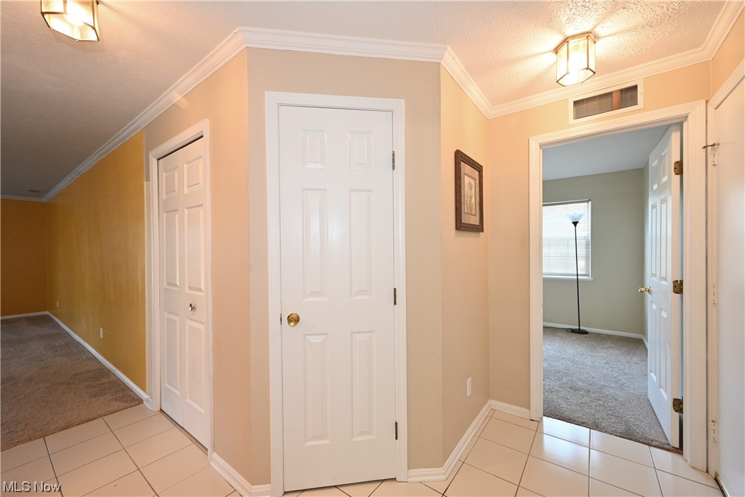 28140 Detroit Road, Unit A1 Westlake, OH 44145 - Photo 9 of 30 Hall with light tile floors, ornamental molding, and a textured ceiling