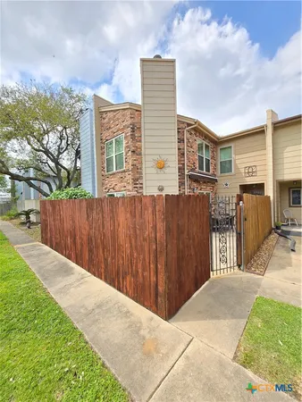 a pathway of a house with wooden fence