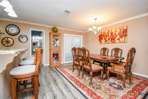 a living room with furniture a flat screen tv and kitchen view
