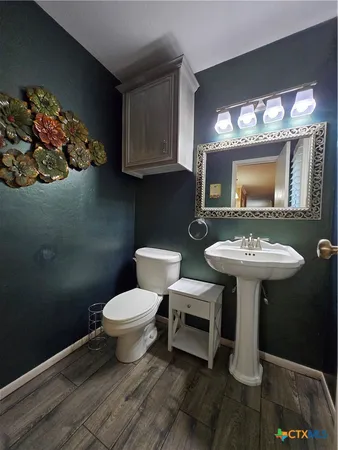 a bathroom with a toilet sink and mirror
