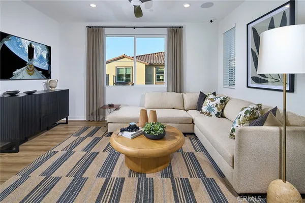 a living room with furniture and a wooden floor