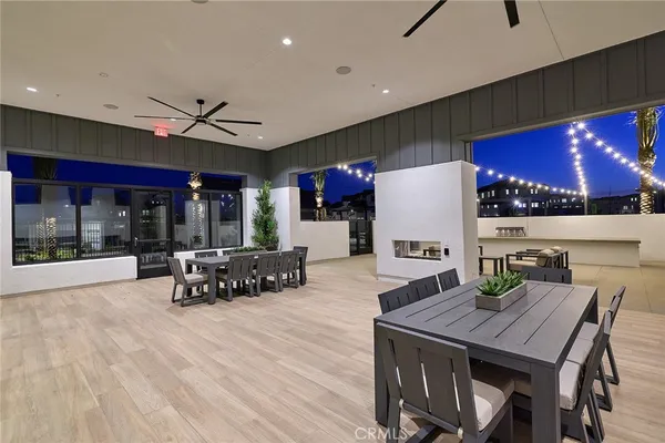 a kitchen with stainless steel appliances granite countertop a stove a dining table and chairs with wooden floor