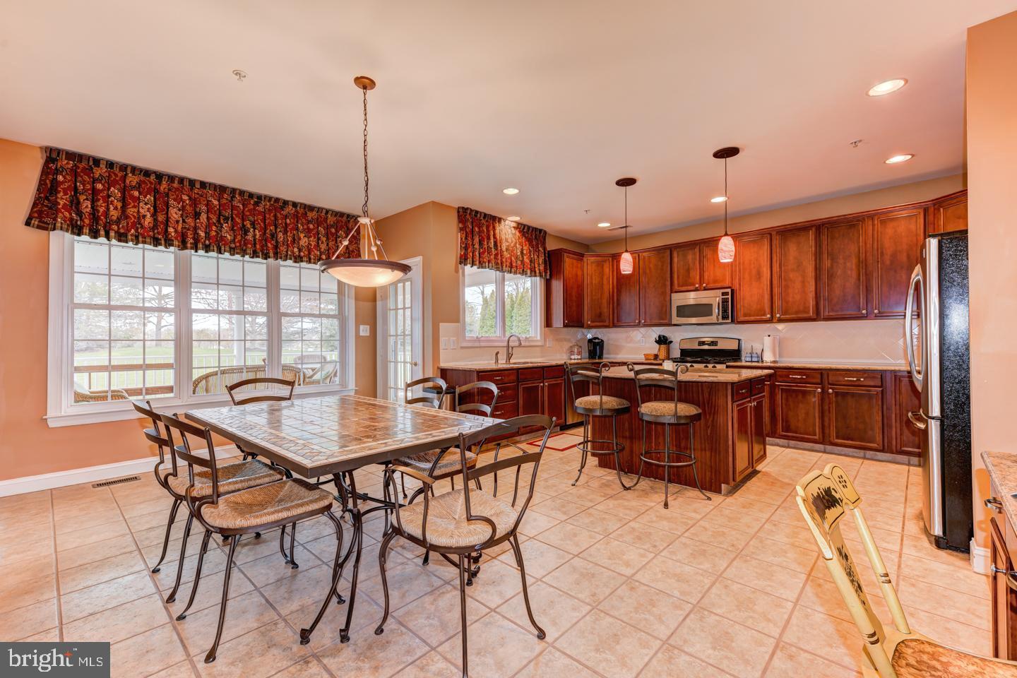 2147 Brookshire Road Furlong, PA 18925 - Photo 11 of 39 a kitchen with stainless steel appliances kitchen island granite countertop a sink a stove a dining table and chairs