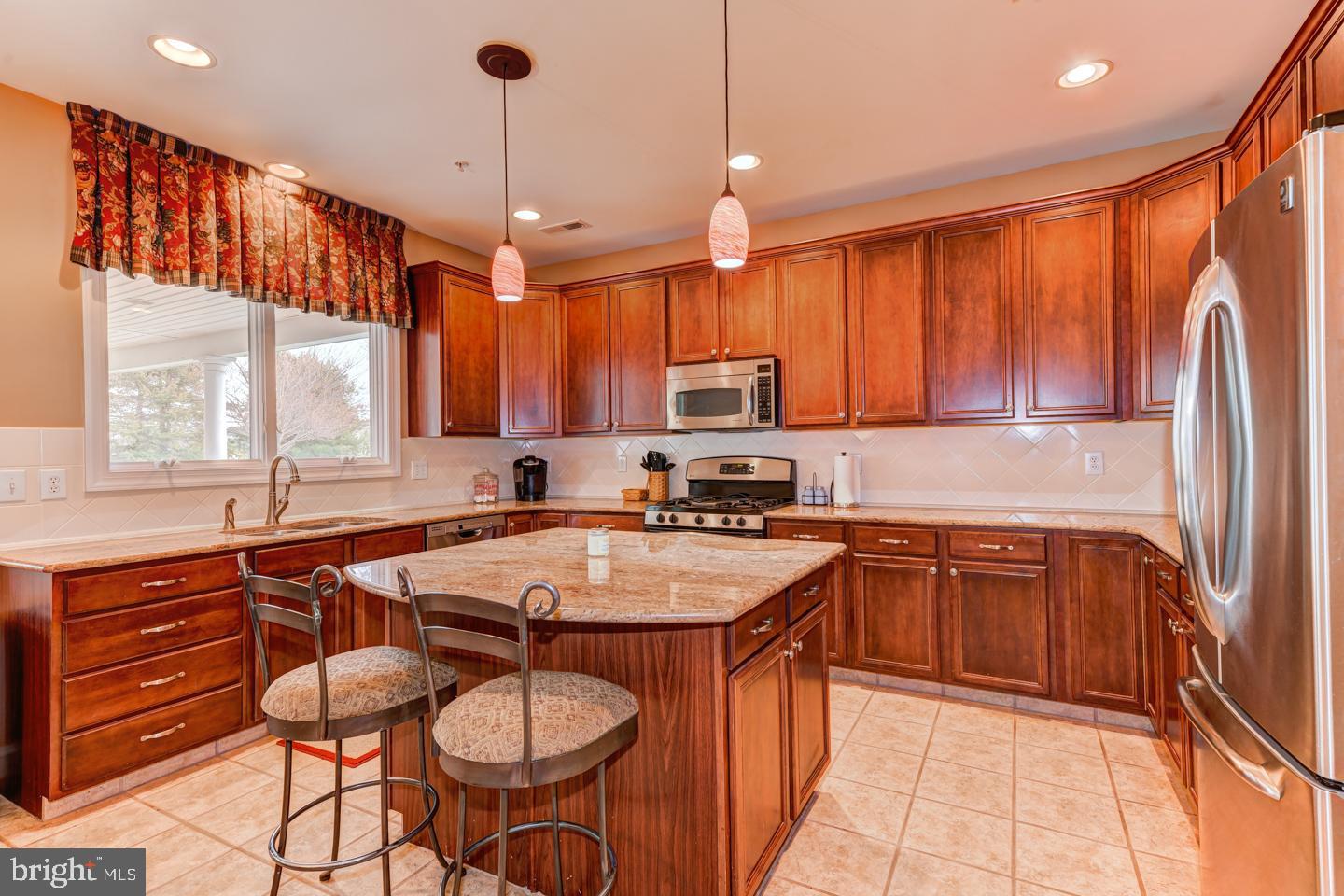 2147 Brookshire Road Furlong, PA 18925 - Photo 9 of 39 a kitchen with stainless steel appliances granite countertop a refrigerator a sink dishwasher a stove a dining table and chairs with wooden floor