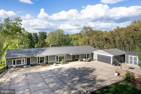 a view of a house with a big yard and a large tree