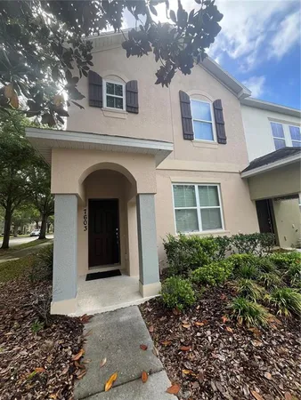 a view of a grey house with a yard