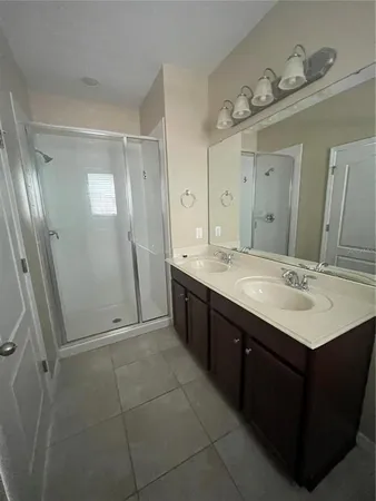 a spacious bathroom with a double vanity sink mirror and shower