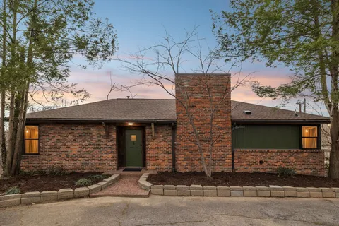 a front view of a house with a tree
