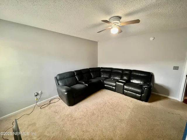 an empty room with ceiling fan and window
