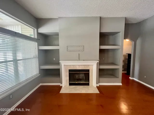 a view of an empty room with a fireplace and a window