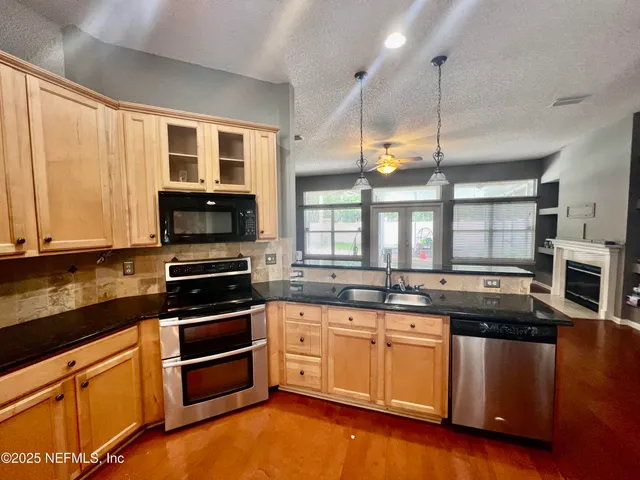 a kitchen with stainless steel appliances granite countertop a refrigerator and a stove top oven