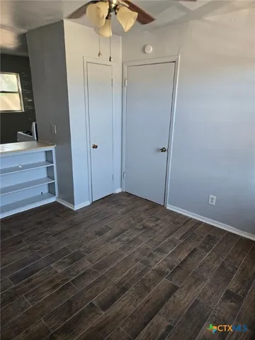 a view of room that has a bed and a flat tv screen on dresser