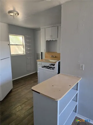 a kitchen with a stove a sink and a refrigerator