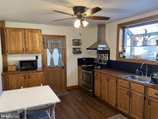 920 3rd Avenue Croydon, PA 19021 - Photo 5 of 12 a kitchen with a stove a sink dishwasher a dining table and chairs with wooden floor