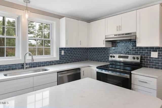 a kitchen with white cabinets and appliances