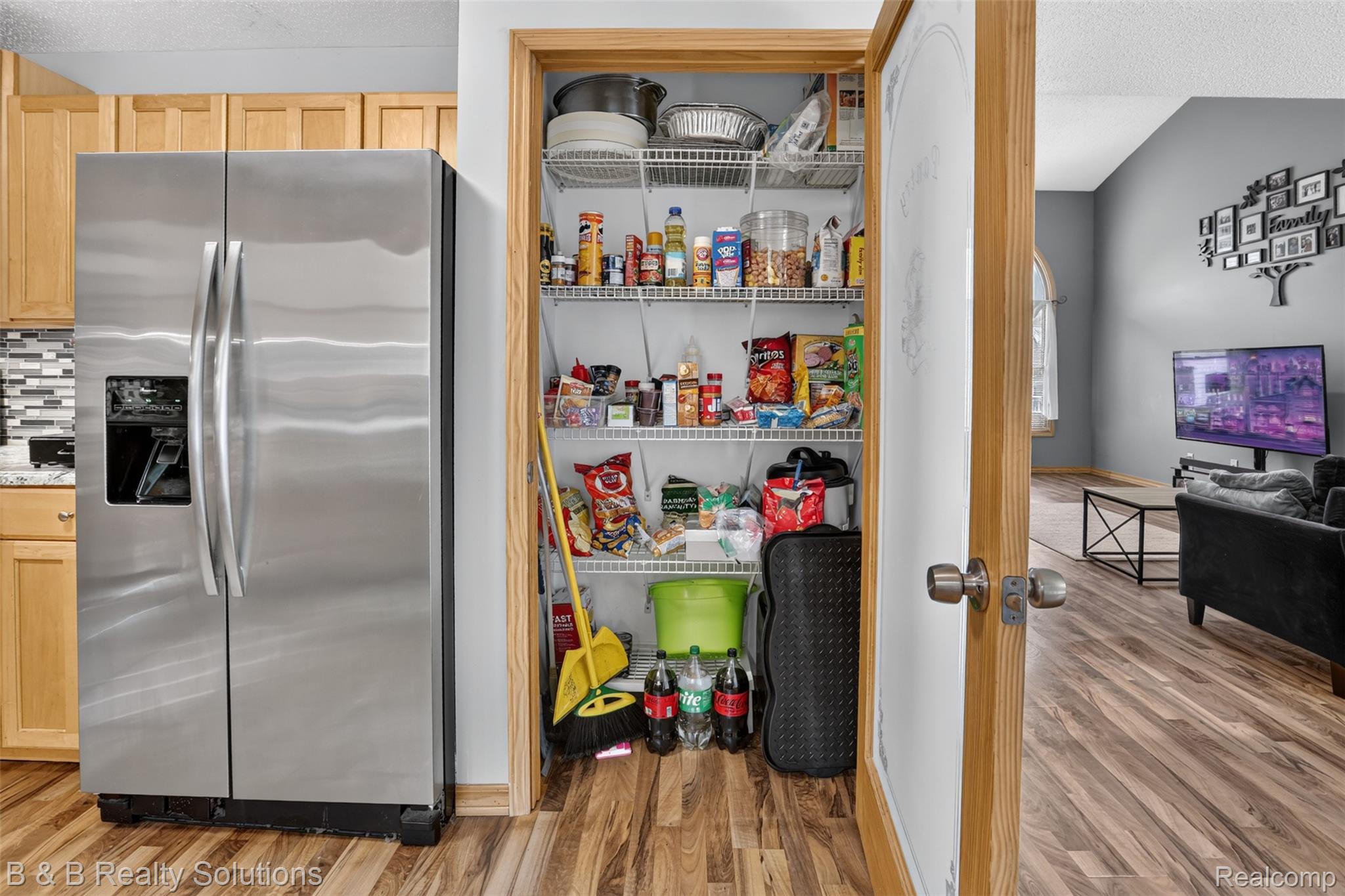 3097 East Burnside Road North Branch, MI 48461 - Photo 14 of 52 Kitchen pantry with wire shelving, light wood-finish flooring, stainless steel side-by-side refrigerator, light wood cabinetry, and a mosaic tile backsplash