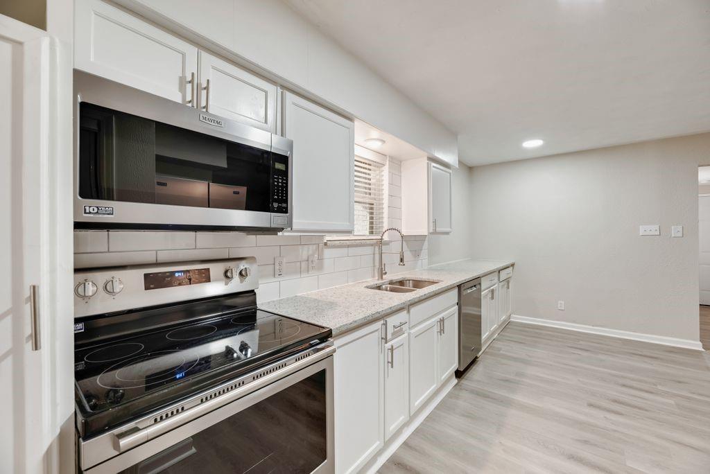 5706 Rocky Ridge Road Dallas, TX 75241 - Photo 8 of 31 a kitchen with stainless steel appliances a stove microwave and sink